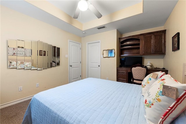 bedroom featuring carpet flooring, a tray ceiling, and ceiling fan