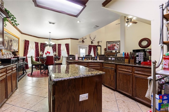 kitchen featuring vaulted ceiling, a kitchen island, a wealth of natural light, and crown molding