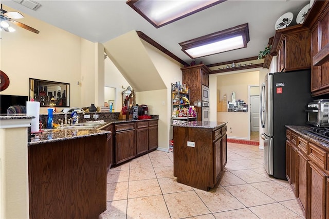 1725 Cliff Maus, Corpus Christi, TX 78416 - kitchen featuring dark stone counters, stainless steel appliances, ceiling fan, and light tile patterned floors