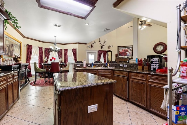 1725 Cliff Maus, Corpus Christi, TX 78416 - kitchen featuring light tile patterned floors, a chandelier, dark stone counters, a center island, and a ceiling fan