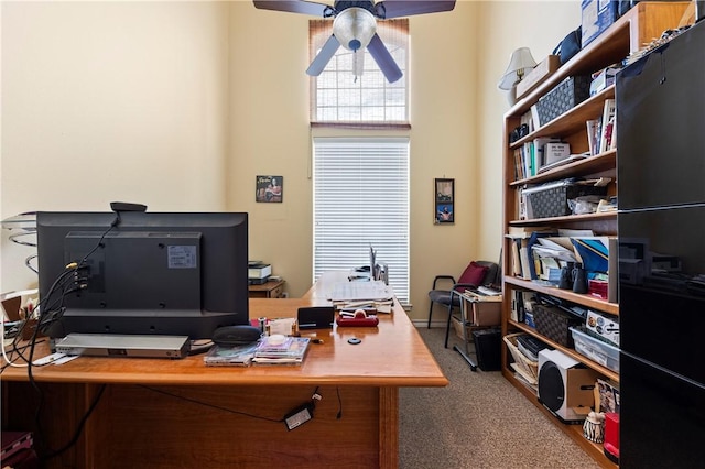 carpeted home office with ceiling fan