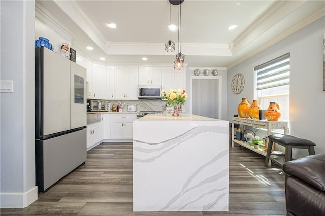2774 Dallas Ave, Ingleside, TX 78362 - kitchen featuring freestanding refrigerator, a center island, a tray ceiling, white cabinetry, and crown molding