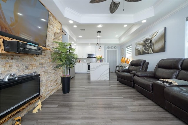 2774 Dallas Ave, Ingleside, TX 78362 - living area with a tray ceiling, a ceiling fan, ornamental molding, wood finished floors, and recessed lighting