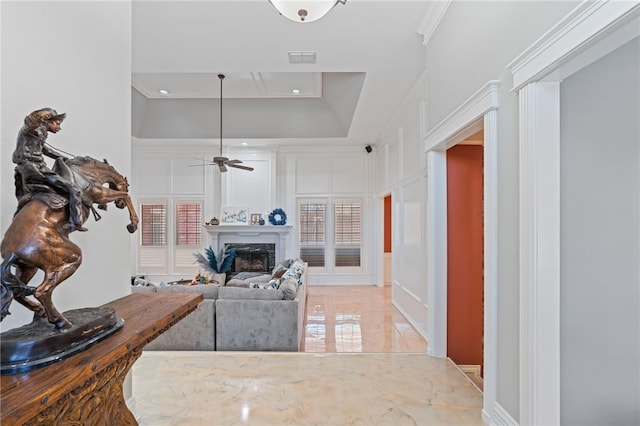 interior space featuring ornamental molding, a premium fireplace, plenty of natural light, and ceiling fan