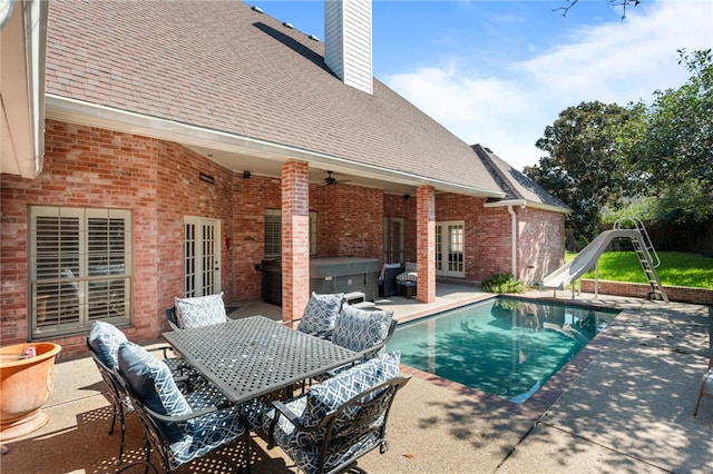 view of pool featuring a water slide, ceiling fan, a patio, and french doors