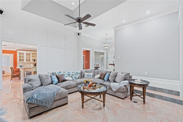 living room with a towering ceiling, ceiling fan with notable chandelier, sink, and crown molding