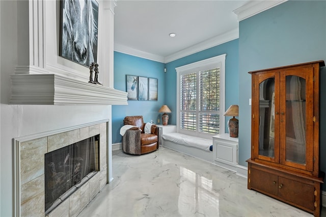 sitting room with a tiled fireplace and crown molding