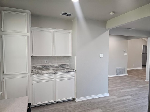 4134 Sierra St, Corpus Christi, TX 78410 - kitchen with white cabinetry, tasteful backsplash, light wood finished floors, and light countertops