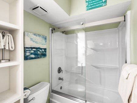 bathroom featuring toilet and enclosed tub / shower combo