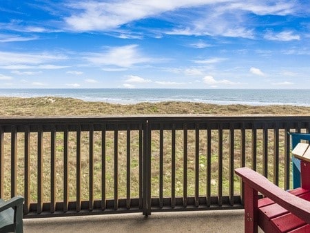 balcony featuring a beach view and a water view