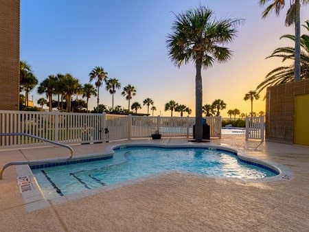 pool at dusk featuring a patio