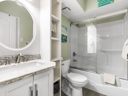 full bathroom with shower / bath combination with glass door, vanity, and toilet