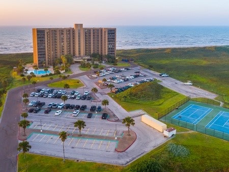 aerial view at dusk with a beach view and a water view