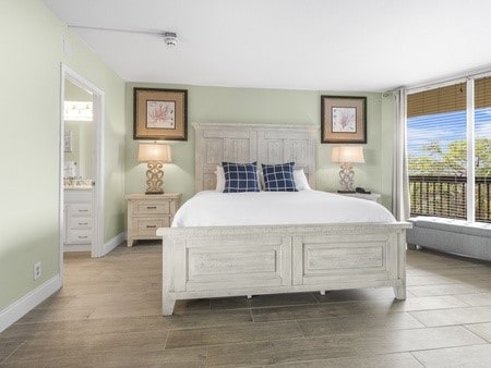 bedroom featuring wood-type flooring and ensuite bath