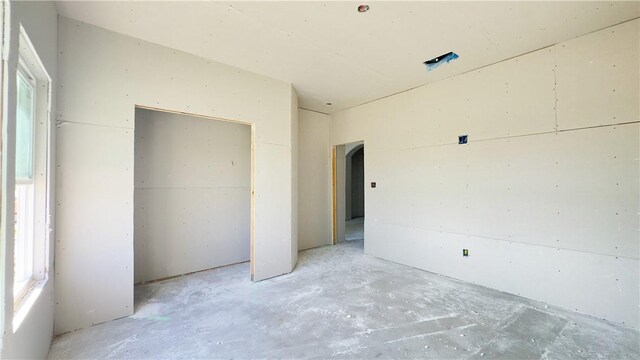 7617 Roman Dr, Corpus Christi, TX 78414 - unfurnished bedroom with unfinished concrete floors, a closet, and arched walkways