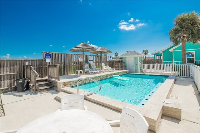 view of swimming pool with a patio and a storage unit