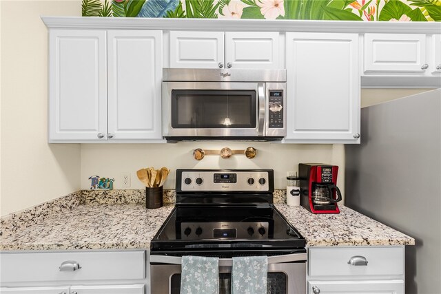 kitchen featuring white cabinetry, light stone countertops, and stainless steel appliances