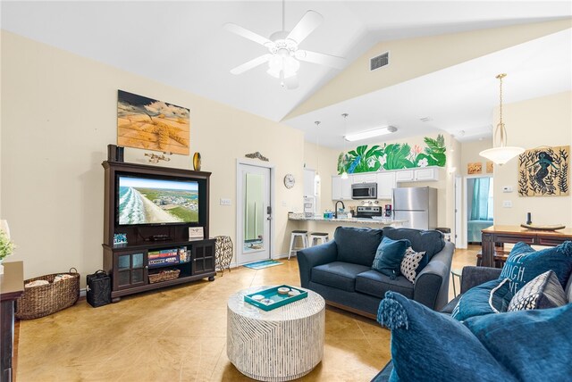 tiled living room featuring ceiling fan, sink, and vaulted ceiling