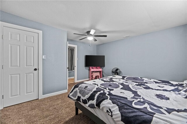 bedroom with ceiling fan, a textured ceiling, and carpet