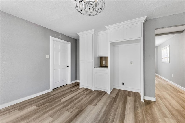 interior space with an inviting chandelier, hardwood / wood-style flooring, and a textured ceiling