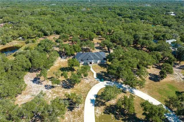 drone / aerial view featuring a wooded view