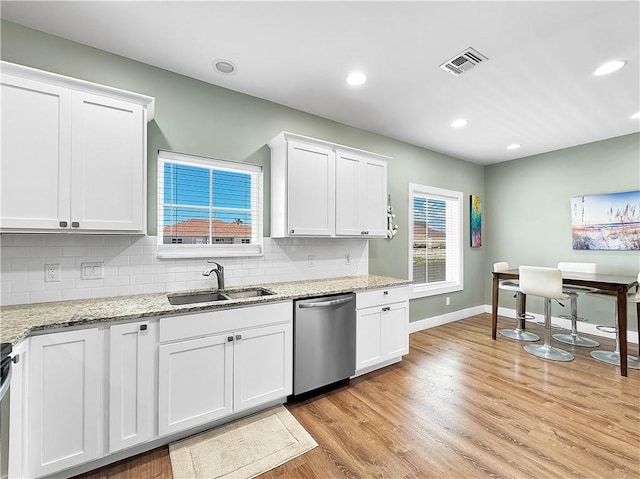 14307 Ridley Way, Corpus Christi, TX 78418 - kitchen featuring dishwasher, a sink, light wood-style floors, white cabinetry, and baseboards
