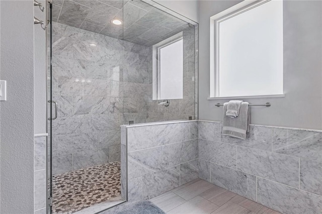 bathroom featuring a stall shower and tile walls