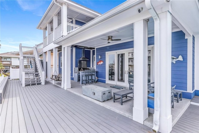 deck with french doors, a ceiling fan, and stairway