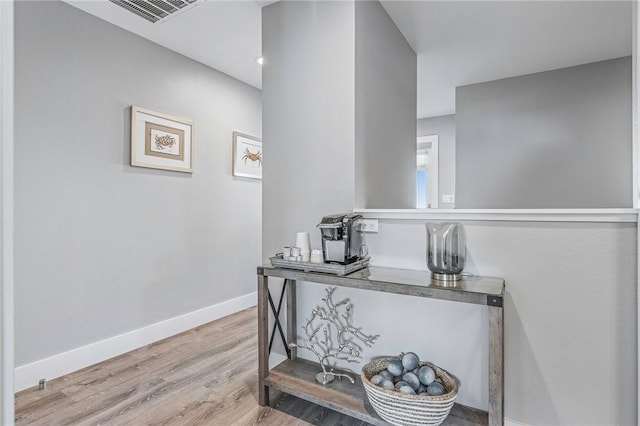 interior space with baseboards, visible vents, and wood finished floors
