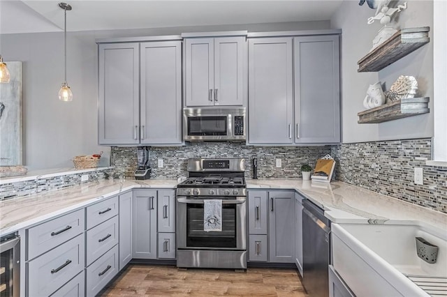 kitchen featuring gray cabinets, open shelves, light stone counters, wine cooler, and stainless steel appliances