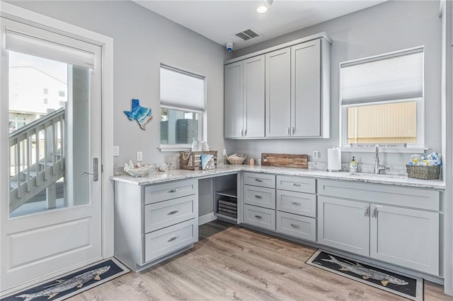interior space featuring a sink, light wood finished floors, and visible vents