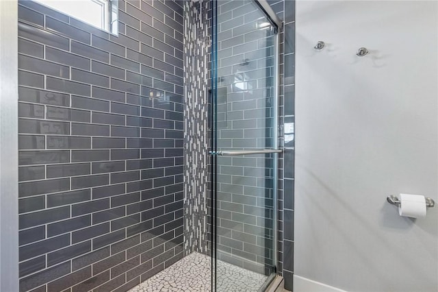 bathroom with baseboards and a stall shower