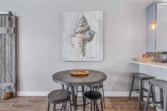 dining area with baseboards and wood finished floors