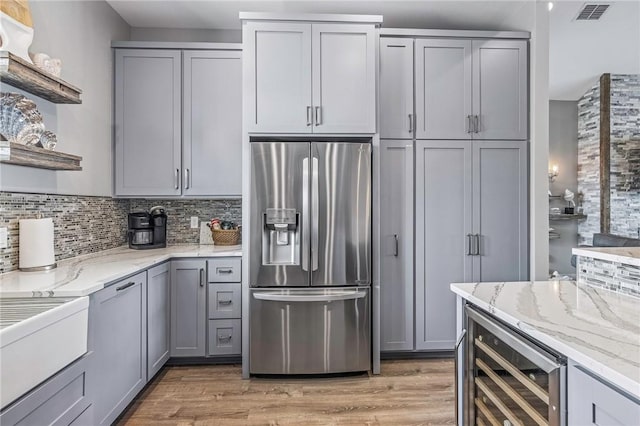 kitchen featuring open shelves, gray cabinets, wine cooler, stainless steel refrigerator with ice dispenser, and visible vents