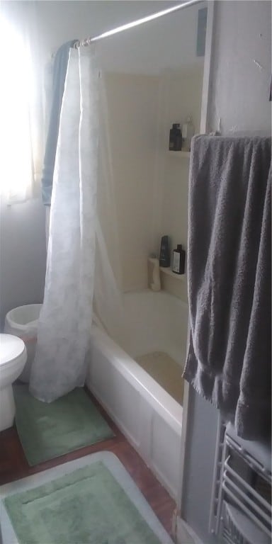 bathroom featuring toilet and shower / bathtub combination with curtain