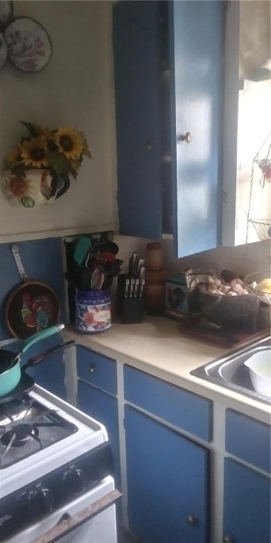 kitchen featuring blue cabinetry and white gas range