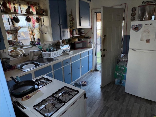 kitchen with light countertops, white appliances, dark wood finished floors, and blue cabinets