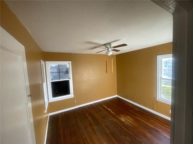 spare room with dark wood-type flooring, ceiling fan, and a textured ceiling