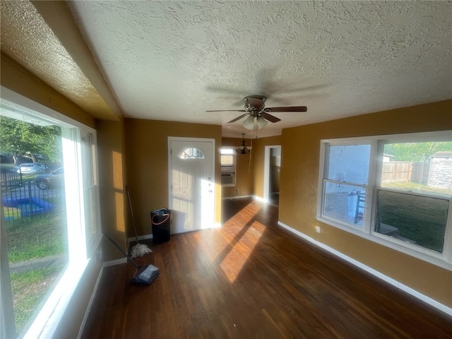 interior space with dark wood-type flooring, ceiling fan, a textured ceiling, and cooling unit