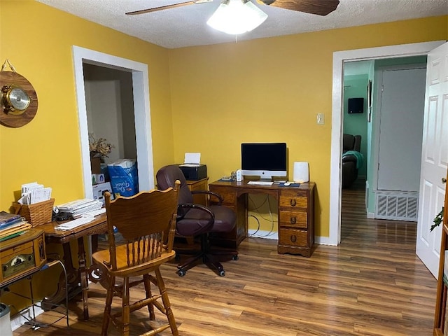 office area with a textured ceiling, wood-type flooring, and ceiling fan