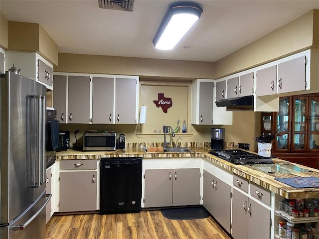 kitchen with gray cabinets, light hardwood / wood-style floors, black appliances, and sink