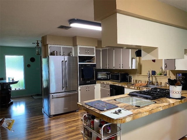 kitchen with black appliances, butcher block countertops, dark hardwood / wood-style floors, sink, and kitchen peninsula