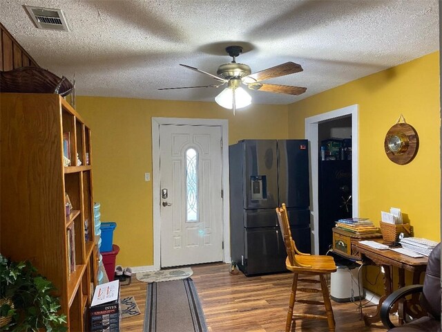 entrance foyer with a textured ceiling, hardwood / wood-style flooring, and ceiling fan