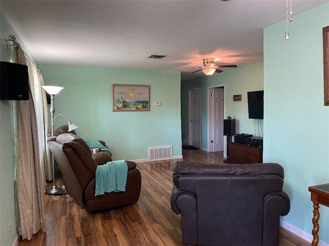 living room featuring ceiling fan and dark hardwood / wood-style floors