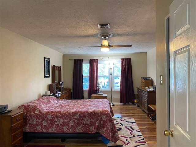 bedroom featuring a textured ceiling, hardwood / wood-style floors, and ceiling fan