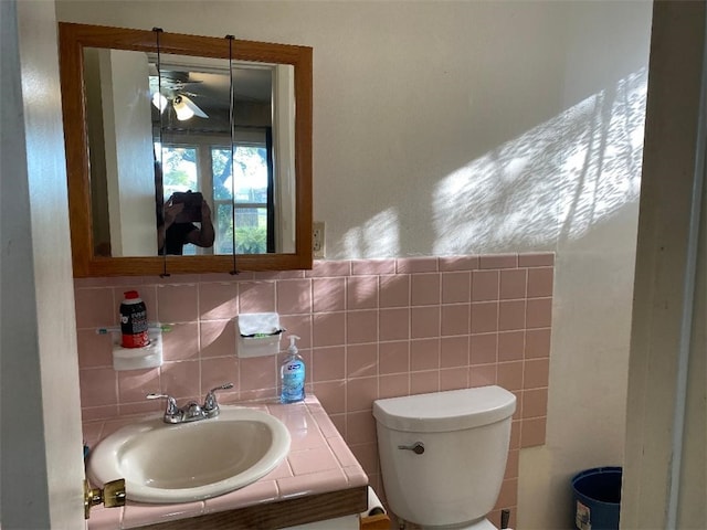 bathroom with ceiling fan, vanity, toilet, and backsplash