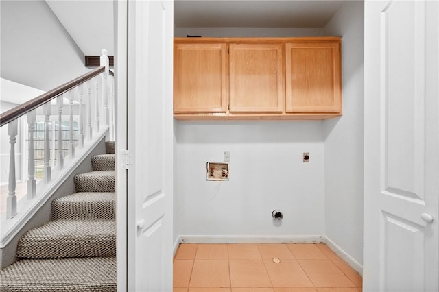 laundry area with light tile patterned floors, hookup for an electric dryer, washer hookup, baseboards, and cabinet space