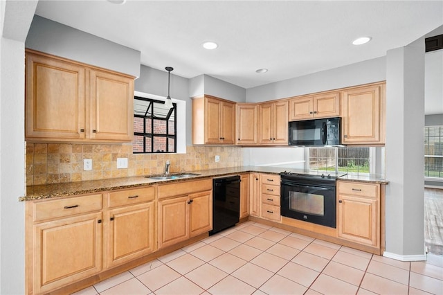 kitchen featuring backsplash, light brown cabinets, a sink, light stone countertops, and black appliances