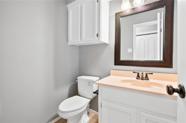 bathroom featuring toilet, vanity, and baseboards