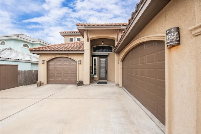 view of front of home with driveway, an attached garage, fence, and stucco siding